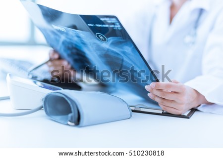 Woman Doctor Looking at X-Ray Radiography in patient's Room Royalty-Free Stock Photo #510230818