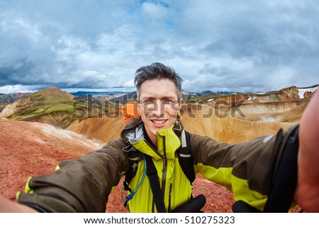 man hiker photographer taking selfie on the rhyolite mountains background in Iceland