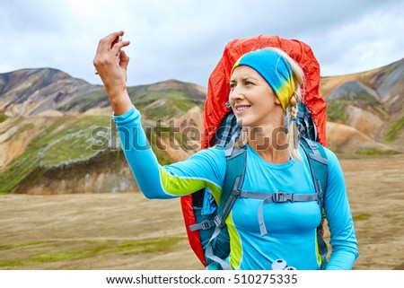 woman hiker photographer taking selfie on the rhyolite mountains background in Iceland