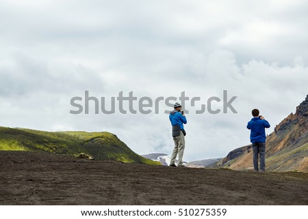 mans hikers photographers taking picture on the lake background in Iceland