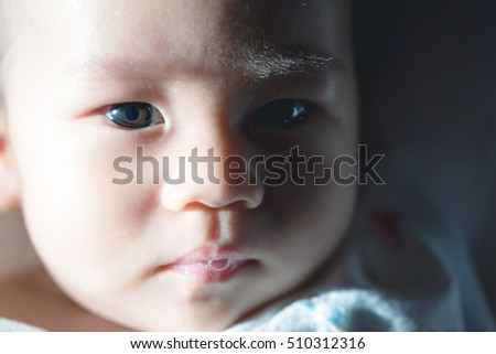 Close up picture of 4 months Asian baby with shadow and eyes detail