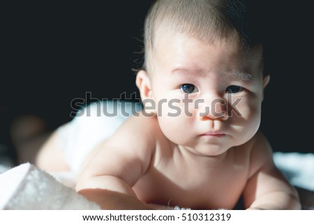 Close up picture of 4 months Asian baby with shadow and eyes detail