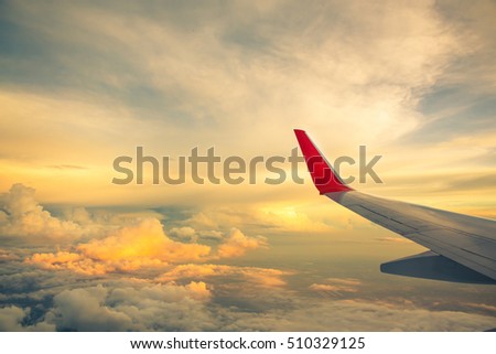 Morning sunrise with Wing of an airplane flying above the ocean. The view from an airplane window. Photo applied to tourism operators. picture for add text message or frame website. Traveling concept