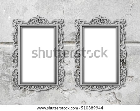 Two gray blank Baroque picture frames on gray weathered concrete wall background