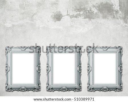 Three silver blank Baroque picture frames on gray concrete wall background