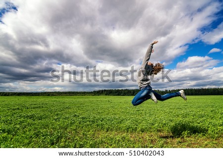 teenage girl jumping in summer field