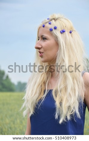 pretty girl in blue dress checking the harvest of corn or grain or cereals