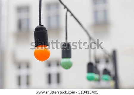Vintage orange and green lamps or garlands on the street