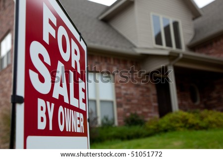 A house with a red for sale sign in the yard