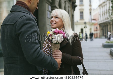 Man gives flowers to his beutiful girlfriend on a date