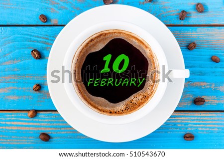 Febryary 10th. Day 10 of month, calendar on morning coffee cup at workplace background. Winter time. Empty space for text
