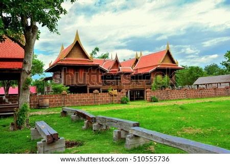 Thai architecture brown wood has path and lawn are common in rural Thailand.