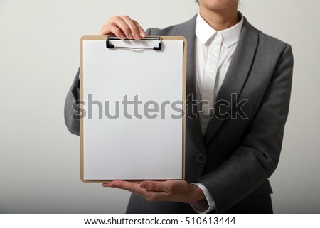 business person holds a clipboard