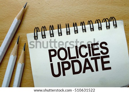 Policies update text written on a notebook with pencils