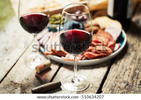 Red wine with charcuterie assortment on the background