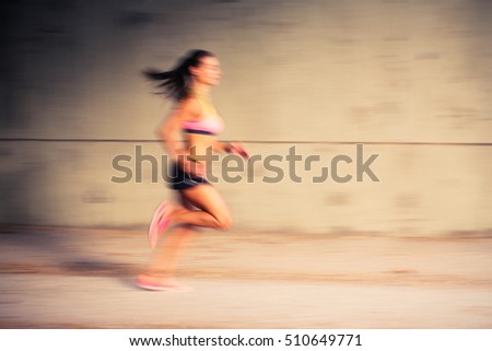 Speed concept - Blurred picture of a woman running fast outdoors