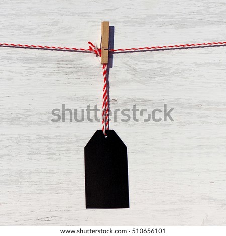 Blank black price tag on the background of white wooden planks