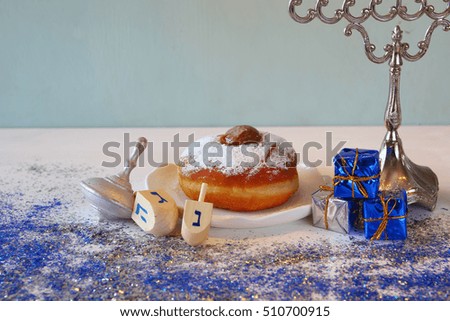 Image of jewish holiday Hanukkah, donut and wooden dreidel (spinning top)