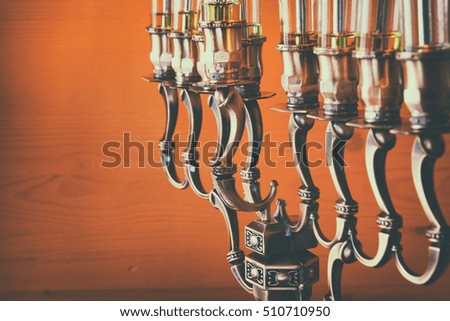 Selective focus image of jewish holiday Hanukkah background with menorah (traditional candelabra) and burning candles. Retro filtered
