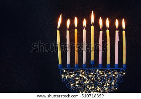Low key Image of jewish holiday Hanukkah background with menorah (traditional candelabra) and burning candles