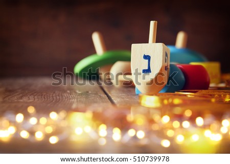 Image of jewish holiday Hanukkah with wooden dreidels colection (spinning top) and chocolate coins on the table