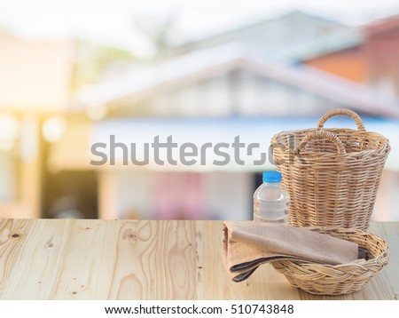 Wicker basket, bottle and fabric on wooden terrace pine.