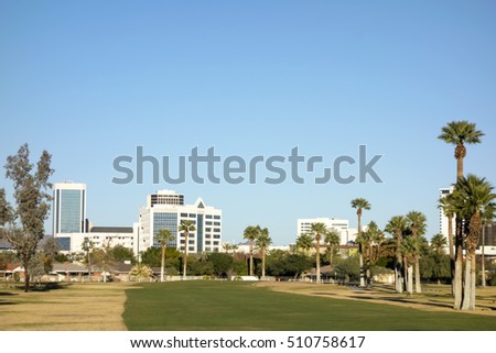 View at Phoenix Downtown from Encanto Park green golf course lawns, Arizona; Copy space in clear blue sky