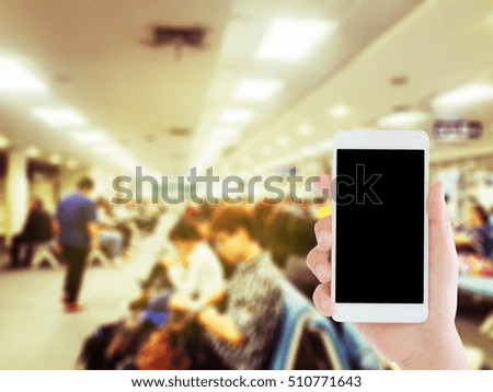 woman use mobile phone and blurred image of people in the airport terminal ,wait for boarding