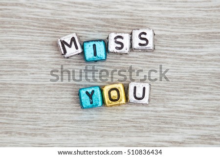 MISS YOU cube blocks arranged on gray wooden background