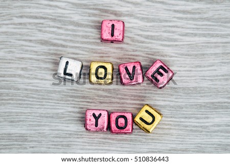 I LOVE YOU cube blocks arranged on gray wooden background