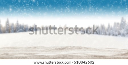 Pile of snow with blur winter panorama. Landscape with spruce trees, blue sky with sun light on background