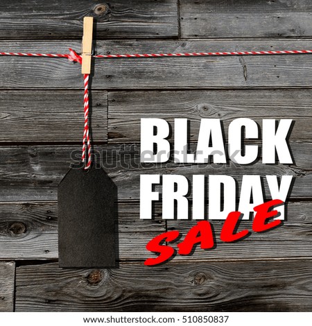 Black friday. Black sale tag on the wooden planks background