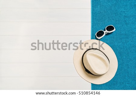 Top view of beach summer accessories with copy space. Lay flat holiday fashion background on white wooden table or floor. Horizontal frame for spa or wellness concept.
