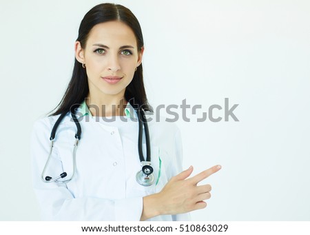 Young female doctor with stethoscope pointing to the  copy space for product or text. Advertisement concept