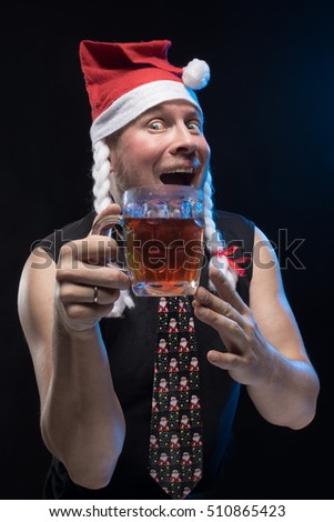 Comic actor man in cap with braids with a glass of beer on a black background, in anticipation of Christmas and New Year