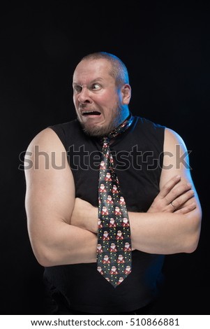 Emotional comic actor gesturing man in a tie on a black background, Christmas and New Year