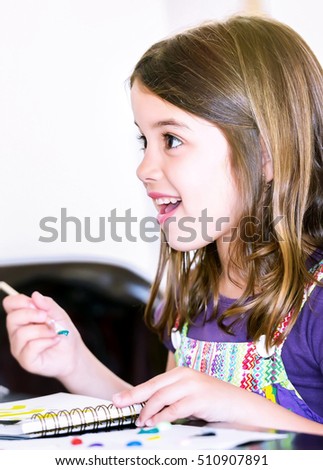 Expressive portrait of a pretty young girl doing paint