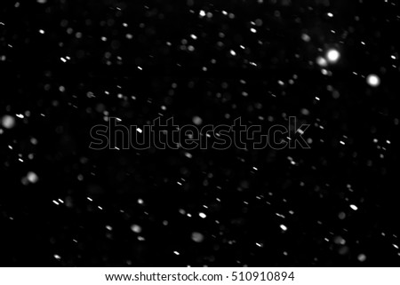 Falling snowflakes on black background.