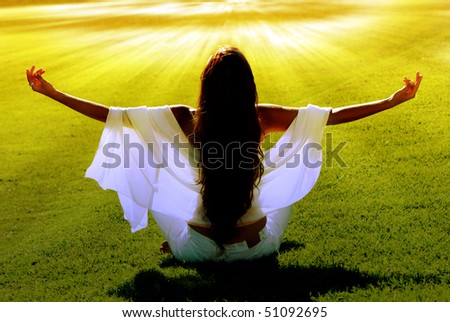 Meditation on a green field in solar beams Royalty-Free Stock Photo #51092695