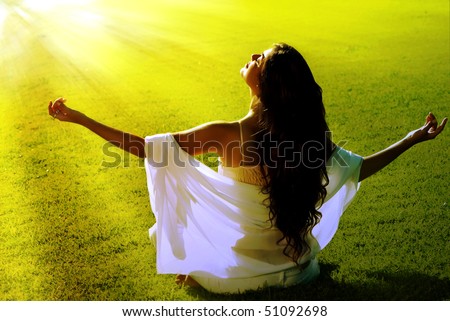 Meditation on a green field in solar beams Royalty-Free Stock Photo #51092698