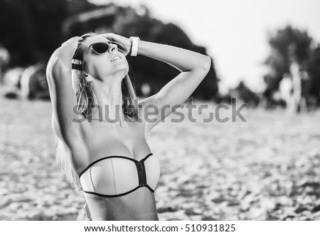 Sporty girl sitting on the beach in swimwear