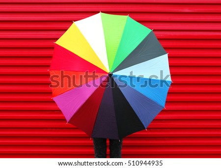 Autumn photo woman holding colorful umbrella over red background 