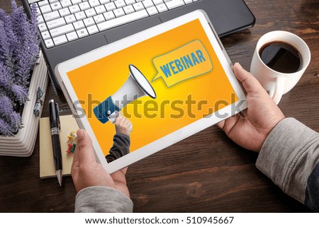 Hand with loudspeaker, WEBINAR word with speech bubble on tablet pc