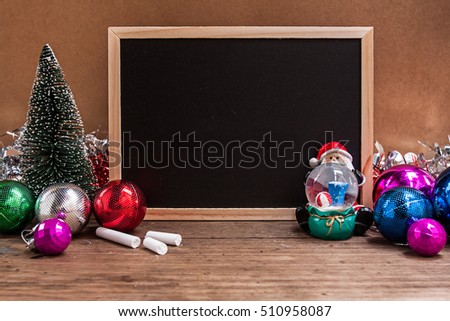blank blackboard for your text on wooden background with manta, christmas tree and Christmas ball decoration image for Christmas holiday concept.