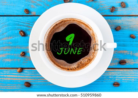 June 9th. Day 9 of month, everyday calendar written on morning coffee cup at blue wooden background. Summer concept, Top view