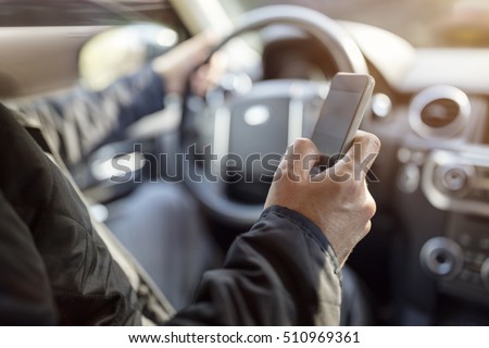 Using a phone in a car texting while driving concept for danger of text message and being distracted Royalty-Free Stock Photo #510969361