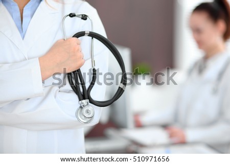 Female doctor standing in a hospital with her colleague in the background