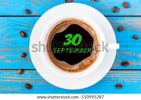 September 30th. Day 30 of month, calendar on morning coffee cup at blue workplace background. Autumn time, Top view
