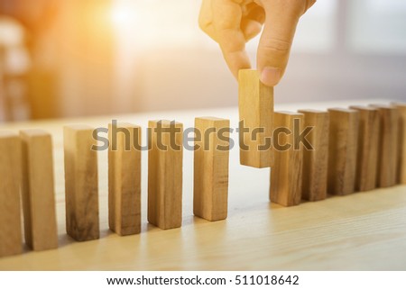 man hand pick one from many wooden blocks.business concept of choosing the right  amongst other ones,Planning,risk and strategy,businessman gambling investment,selective focus,vintage color

