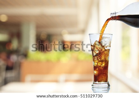 Cola is pouring into glass